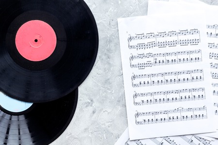 musician work set with paper with notes and vynil record on stone table background top viewの写真素材