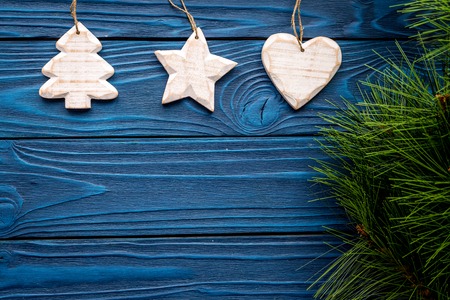 tree, heart and star toys to decorate christmas tree for new year celebration with fur tree branches on blue wooden table background top veiw mockupの写真素材