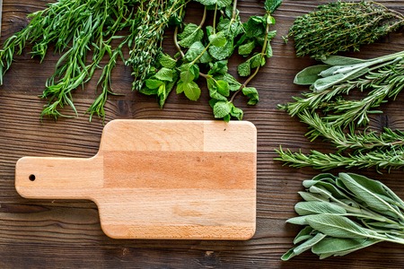 drying fresh herbs and greenery for spice home food on wooden kitchen desk background top view space for textの写真素材