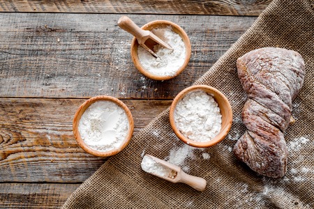 fresh tasty bread with wheat flour in bakery shop on wooden desk background top viewの写真素材