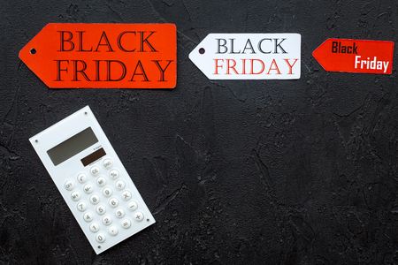 Words black friday on red label near and calculator on black stone background top view.の写真素材
