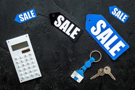 Count the benefits from the sale. Word sale on colorful labels near calculator on black stone background top view copyspace.の写真素材