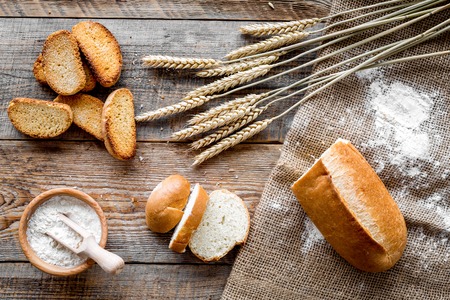 baking fresh wheaten bread on bakery work table wooden background top view