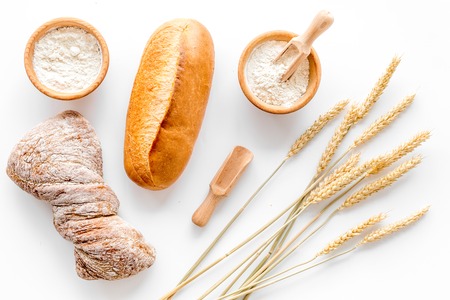 baking fresh wheaten bread on bakery work table white background top view