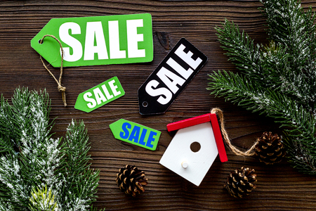 Christmas sale. Sale labels near spruce branch and xmas toys on dark wooden background top view copyspaceの写真素材