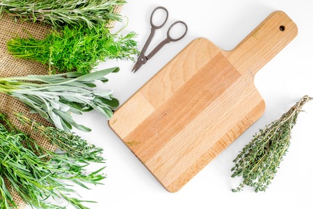 flat lay with fresh herbs and greenery for drying and making spices set on white kitchen background mock-upの写真素材