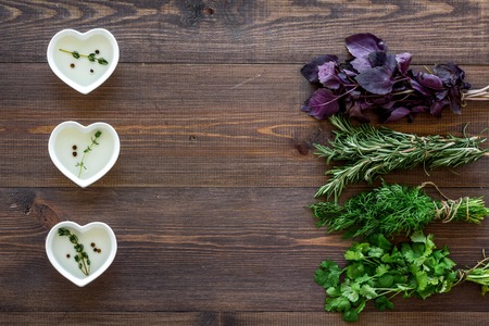 home cooking with fresh greenery and organic oil on wooden table background top view mock upの写真素材