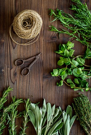 making spices with fresh herbs and greenery for cooking wooden kitchen table background top viewの写真素材