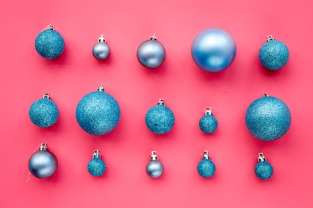 Christmas toys. Blue balls on pink background top view.の写真素材
