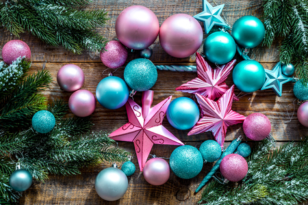 Decorate the christmas tree. Pink and blue stars and balls near pine branches on wooden background top view.の写真素材