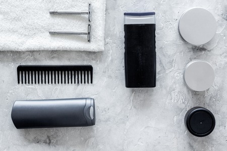 Men's shaving. Tools and cosmetics on grey stone background top view.