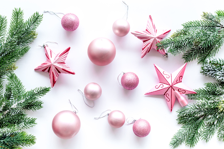 Christmas toys. Pink stars near pine branches on white background top view.の写真素材