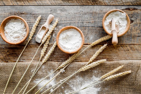 wheat and rye ear for flour production in bakery shop on wooden desk background top viewの写真素材