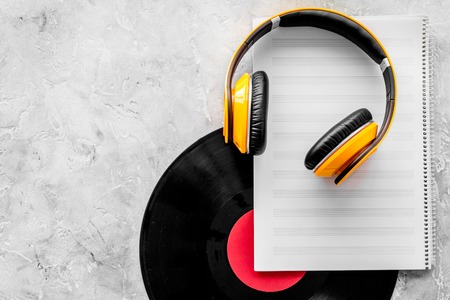 Compose music. Vinyl records, headphones, music notes on grey background top view.