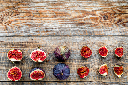 Fresh blue figs slices pattern on rustic wooden background top view.の写真素材