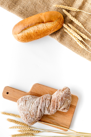 baking bread with wheat flour and ears on table white background in bakery top viewの写真素材
