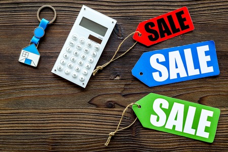 Count the benefits from the sale. Word sale on colored labels near calculator on wooden background top view copyspaceの写真素材
