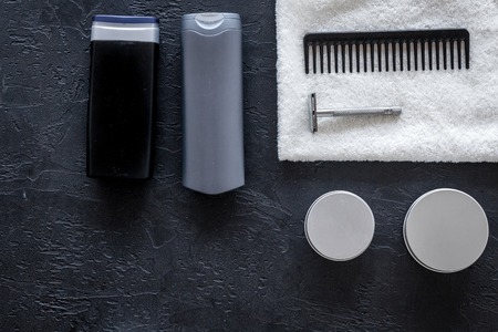 Mens cosmetics for hair care and shaving. Shampoo, gel, razor, wax on black background top view copyspaceの写真素材