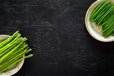 Fresh asparagus on the plates on black background top view.の写真素材