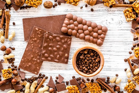 Chocolate bars of different varietes on grey wooden background top view.