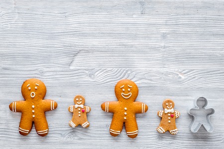 Gingerbread man on grey wooden background top view.