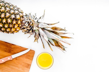 Preparing pineapple juice. Cut pineapple with a knife on white background top view.の写真素材