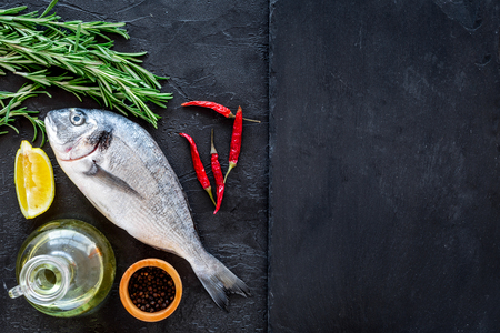 Preparing fresh sea fish. Black background top view.の写真素材