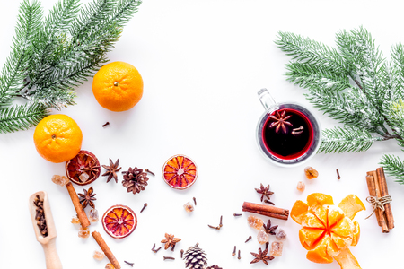 Hot mulled wine or grog cooking for new year celebration with oranges and spices ingredients on white background flat layの写真素材