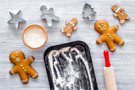 Make gingerbread cookie for new year 2018. Gingerbread man, rolling pin, flour on grey wooden...