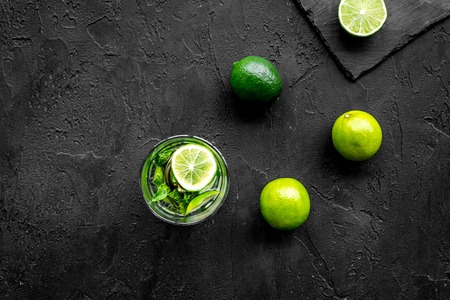 Glass of mojito, lime, mint on black stone background top view.の写真素材