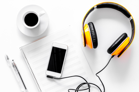 Worktable of composer today. Headphones, phone, music notes on white background top view.の写真素材