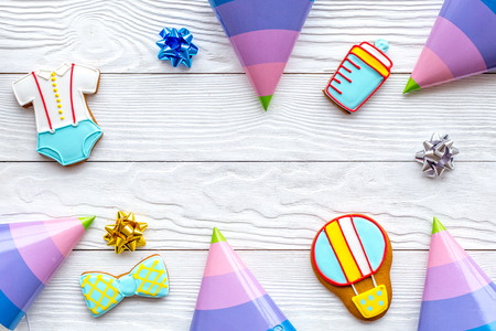 Treat for baby birthday party with gingerbread cookies frame on white wooden table background top view mock-upの写真素材