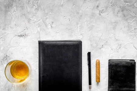 Man set. Whiskey with ice, cigar, wallet and notebook on stone gray bar background top view copyspaceの写真素材