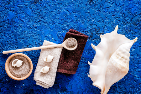 Spa cosmetic set with sea salt for bath and shell on blue table background top view mockupの写真素材