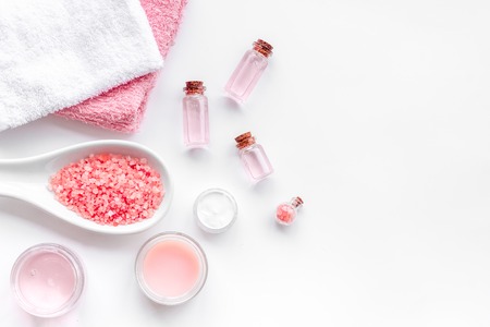 Spa products with rose oil. Cream, lotion and salt on white background top view copyspaceの写真素材