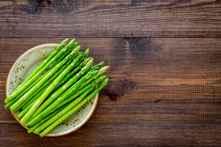 Sprouts of fresh asparagus on dark wooden background top view copyspaceの写真素材