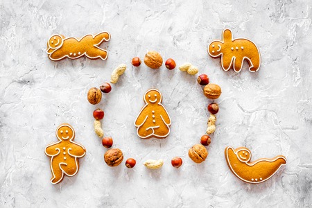 Healthy food for sportsman. Cookies in shape of yoga asanas near nuts on stone table background top...