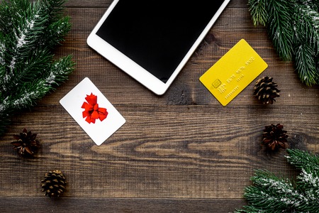 Online payment for christmas present with credit card and device on wooden background top view.の写真素材