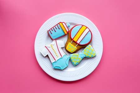 Cook gingerbread cookies on plate for baby shower on pink background top view mockup