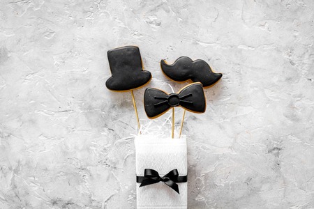 Men birthday concept. Set of cookies in shape of black tie, mustache and hat. Grey stone background top view copyspaceの写真素材