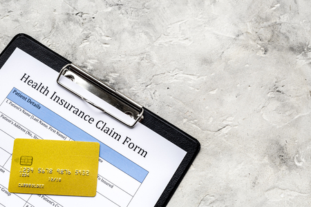 Buy health insurance. Document, pad, pen and bank card on grey background top view copyspaceの写真素材