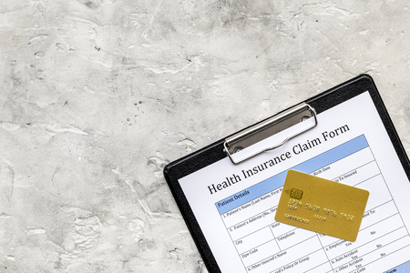 Buy health insurance. Document, pad, pen and bank card on grey background top view copyspaceの写真素材