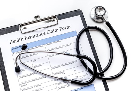 Health insurance for reception at the doctor. Document, stethoscope, pad on white background top viewの写真素材