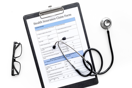Health insurance for reception at the doctor. Document, stethoscope, pad, glasses on white background top viewの写真素材