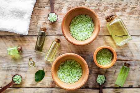 Spa salt and lotions for skin with tea tree oil on rustic wooden top view patternの写真素材