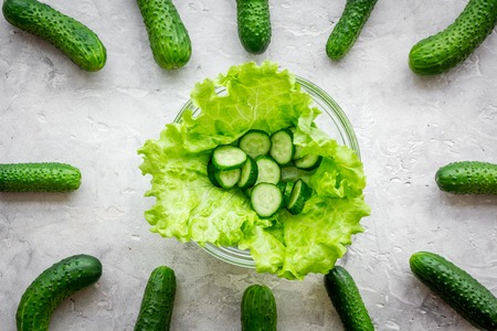 Make a salad with fresh cucumbers and salad. Grey top viewの写真素材