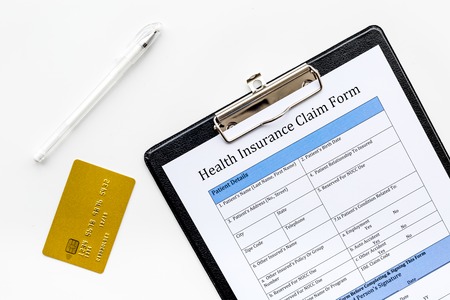 Buy health insurance. Document, pad, pen and bank card on white background top viewの写真素材