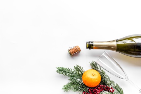 New year eve. Spruce branch, glasses, champagne bottle, tangerines on white top view copyspace