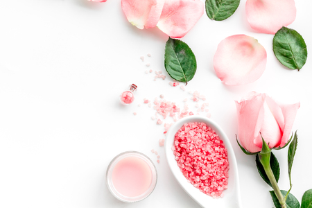 Pattern with rose oil cosmetics. Rose petals, spa salt on white top view copyspaceの写真素材