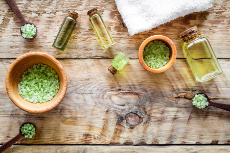 Spa salt and lotions for skin with tea tree oil on rustic wooden background top view.の写真素材